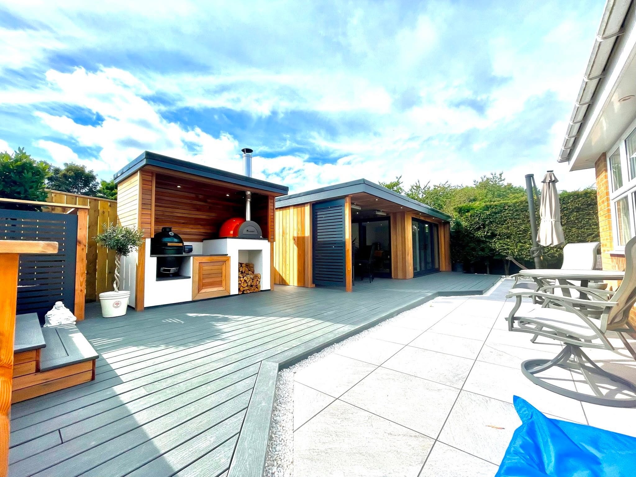 Garden room with adjoining outdoor kitchen, pizza oven and composite decking